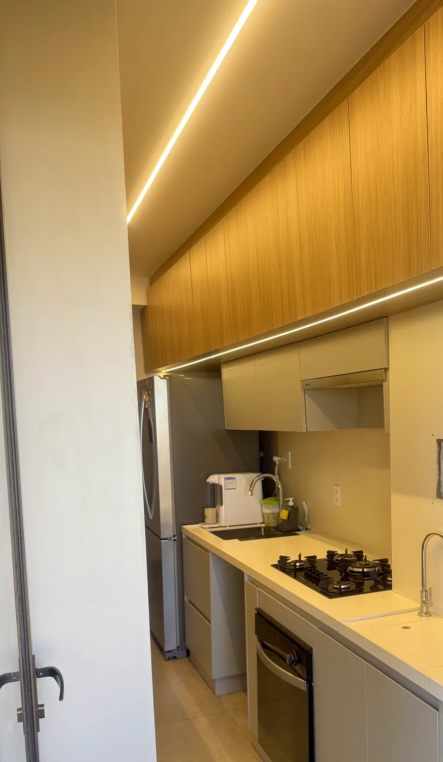 Cozinha planejada com armários amadeirados e LED embutido, em Águas Claras, Brasília DF