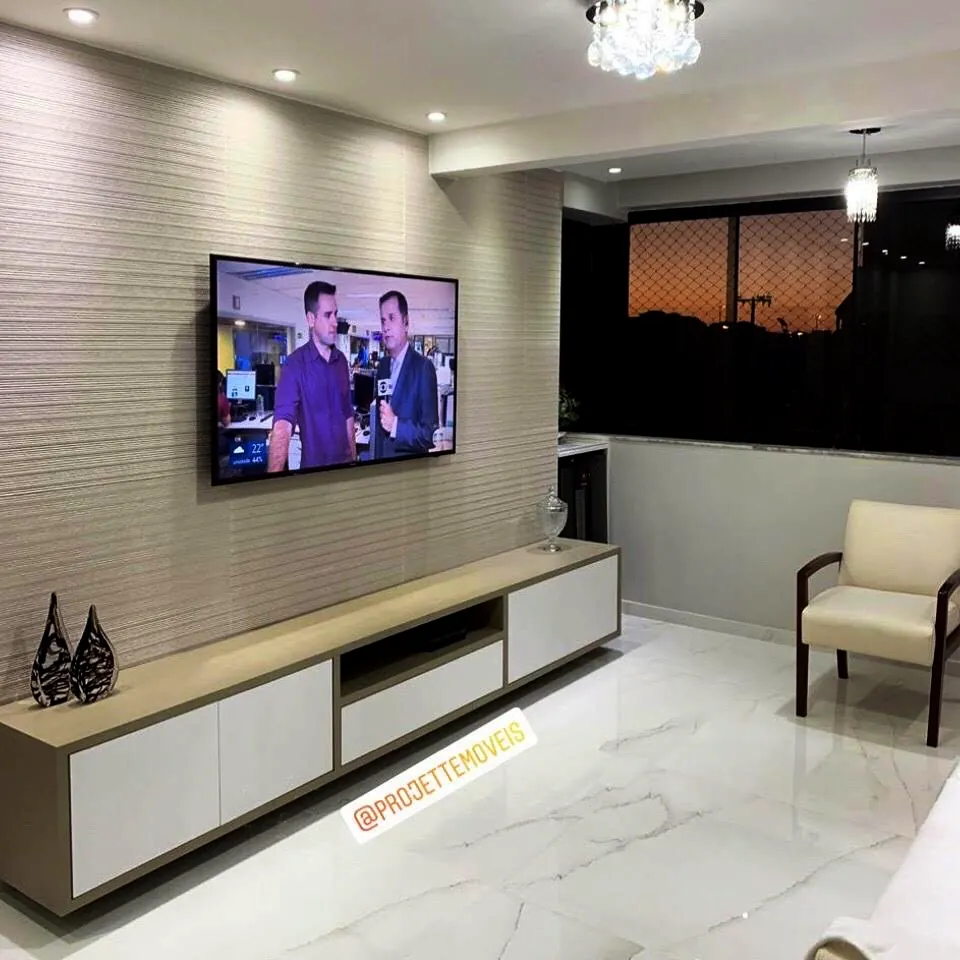 Painel de TV com rack suspenso em laca clara, sala de apartamento em Brasília